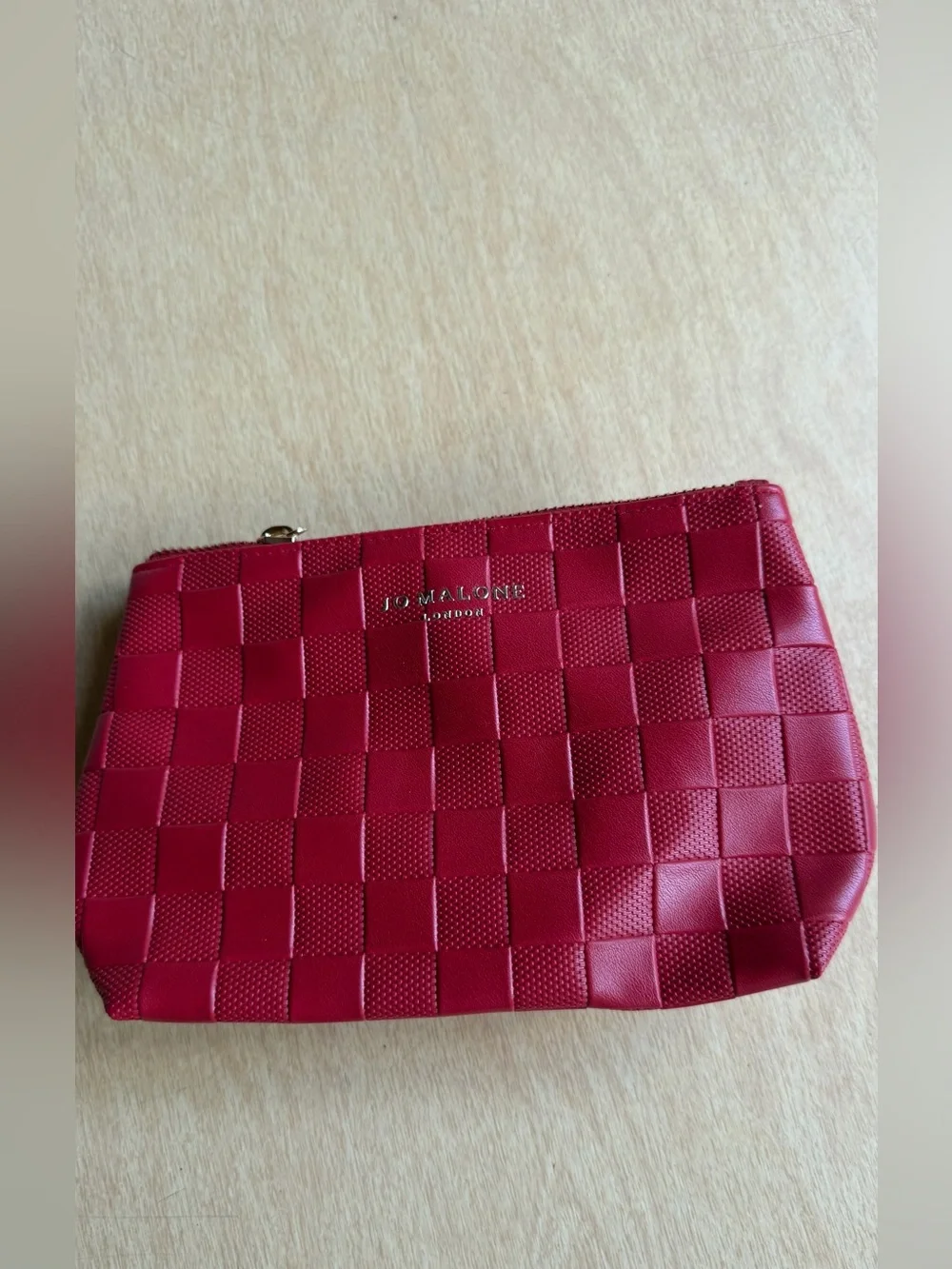 Jo Malone London cosmetic bag features a vibrant red woven design